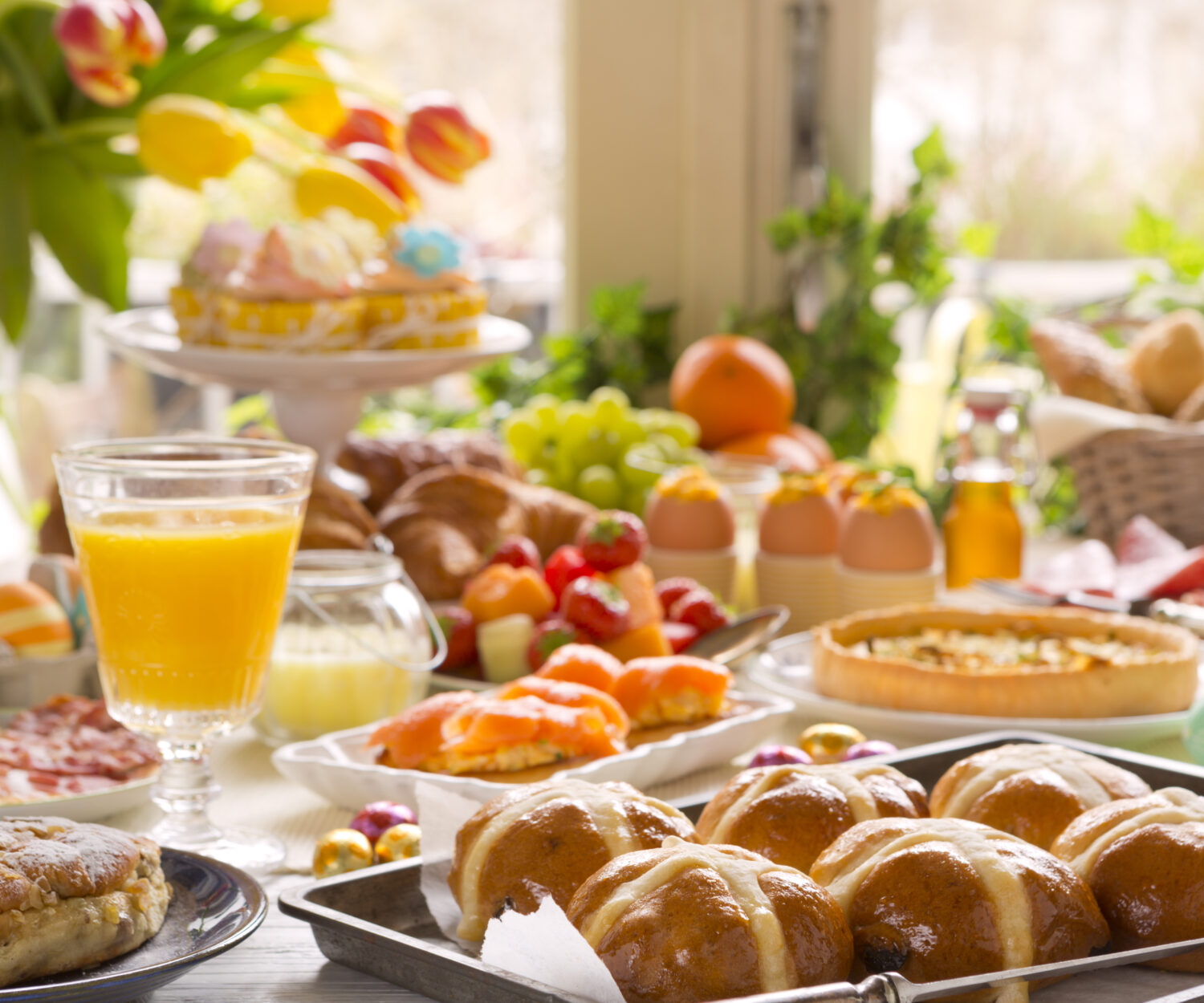 Breakfast or brunch table filled with all sorts of delicious delicatessen ready for an Easter meal.