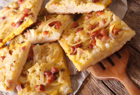 Quadratisch geschnittene Stücke vom Zwiebelkuchen mit Speck