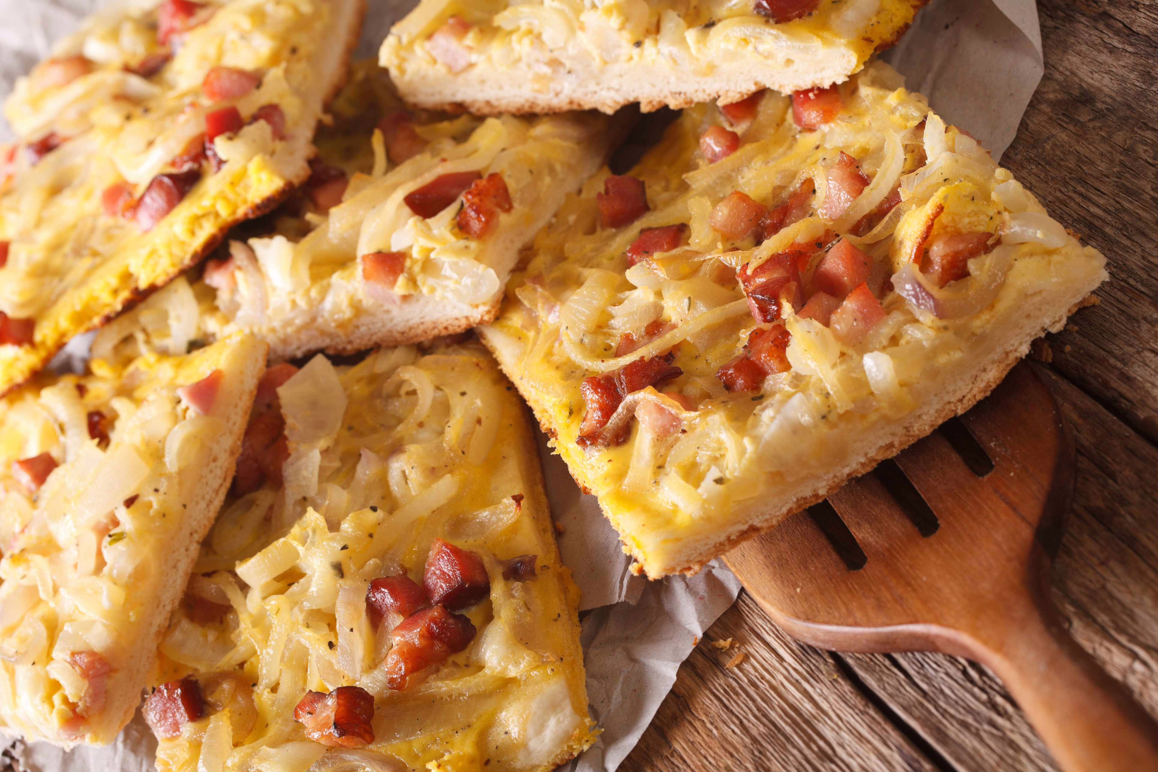 Quadratisch geschnittene Stücke vom Zwiebelkuchen mit Speck