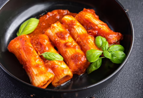 5 Vegane Canneloni mit Tomatensoße leicht bedeckt in schwarzer Pfanne